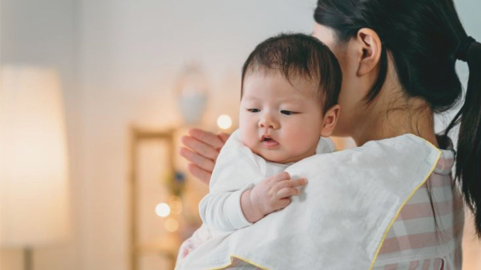 A woman gently cradles a baby in her arms, showcasing a tender moment of care and affection.