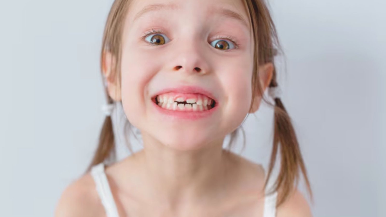 A young girl with her mouth open, smiling