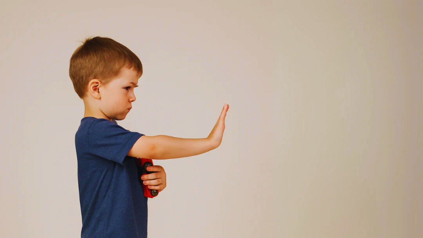 A young boy points excitedly at something off-screen, showcasing curiosity and engagement.