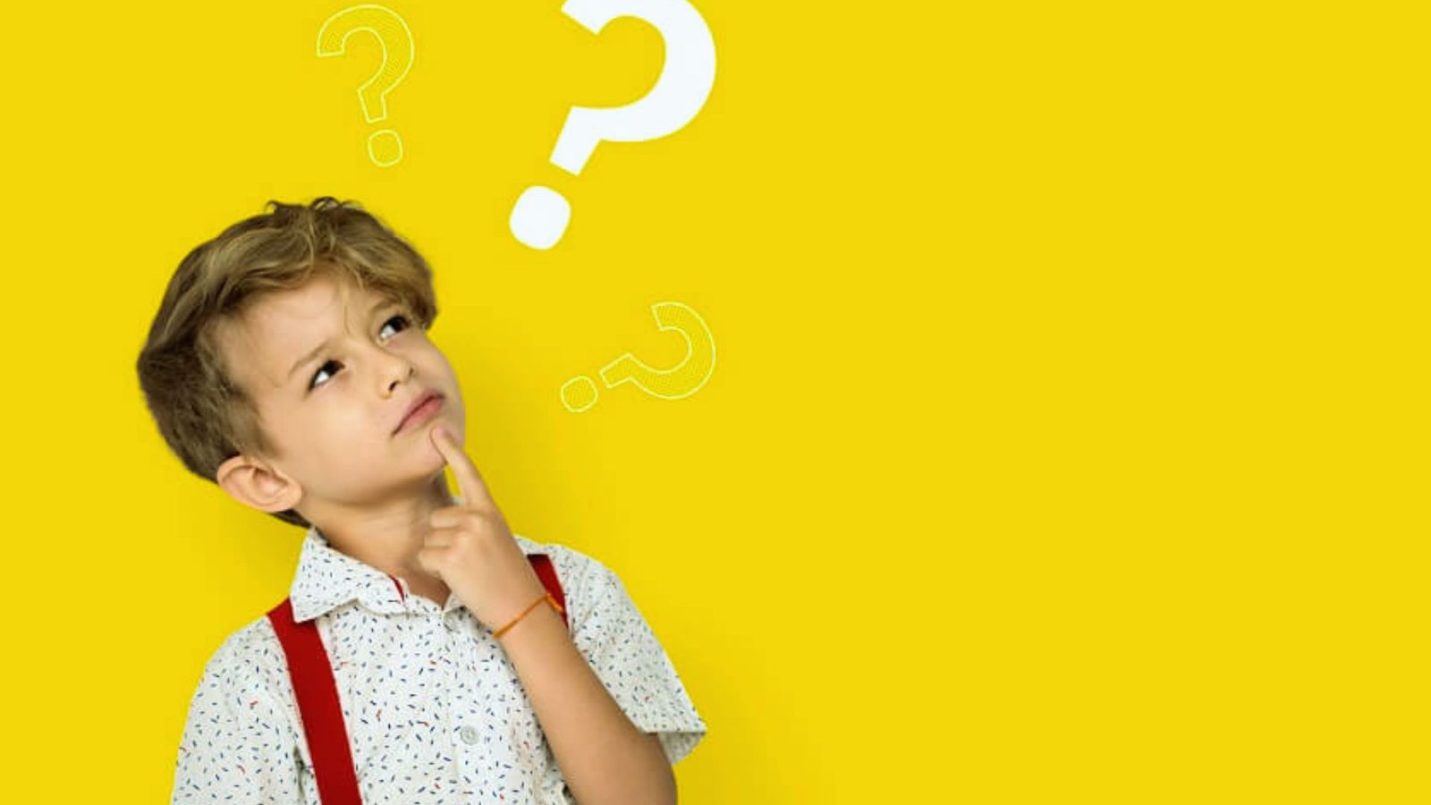 A young boy with a curious expression is deep in thought against a bright yellow background