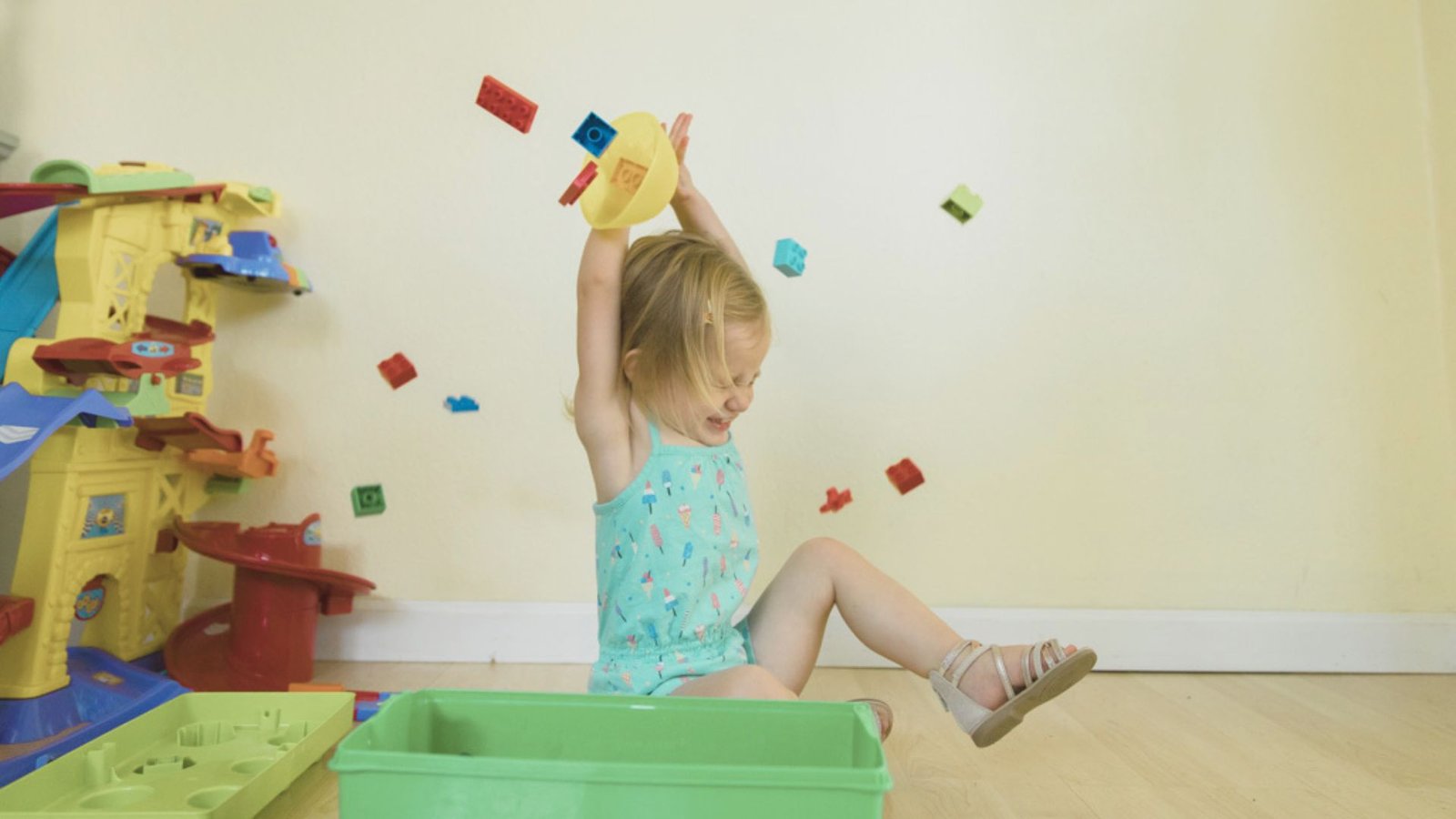 A little girl happily playing with colorful toys in a bright and cheerful playroom.