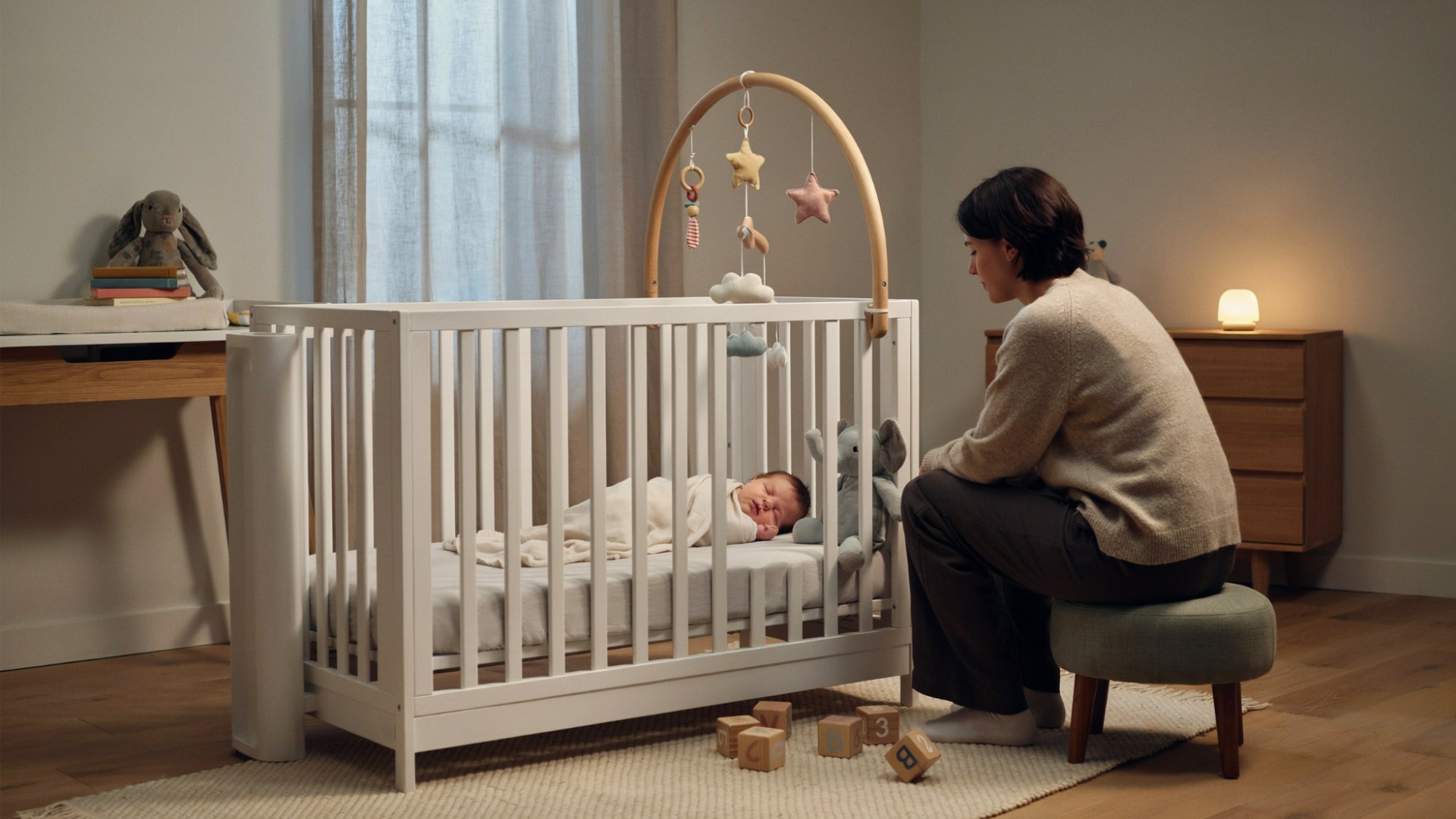 Four-month-old baby sleeping during the night while a parent offers comfort.