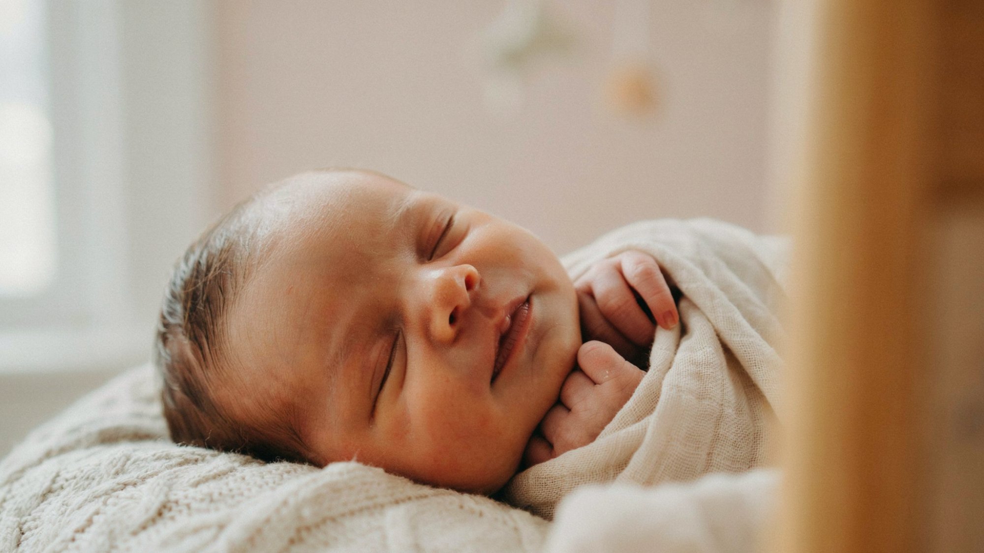 Newborn baby showing natural facial expressions while sleeping.