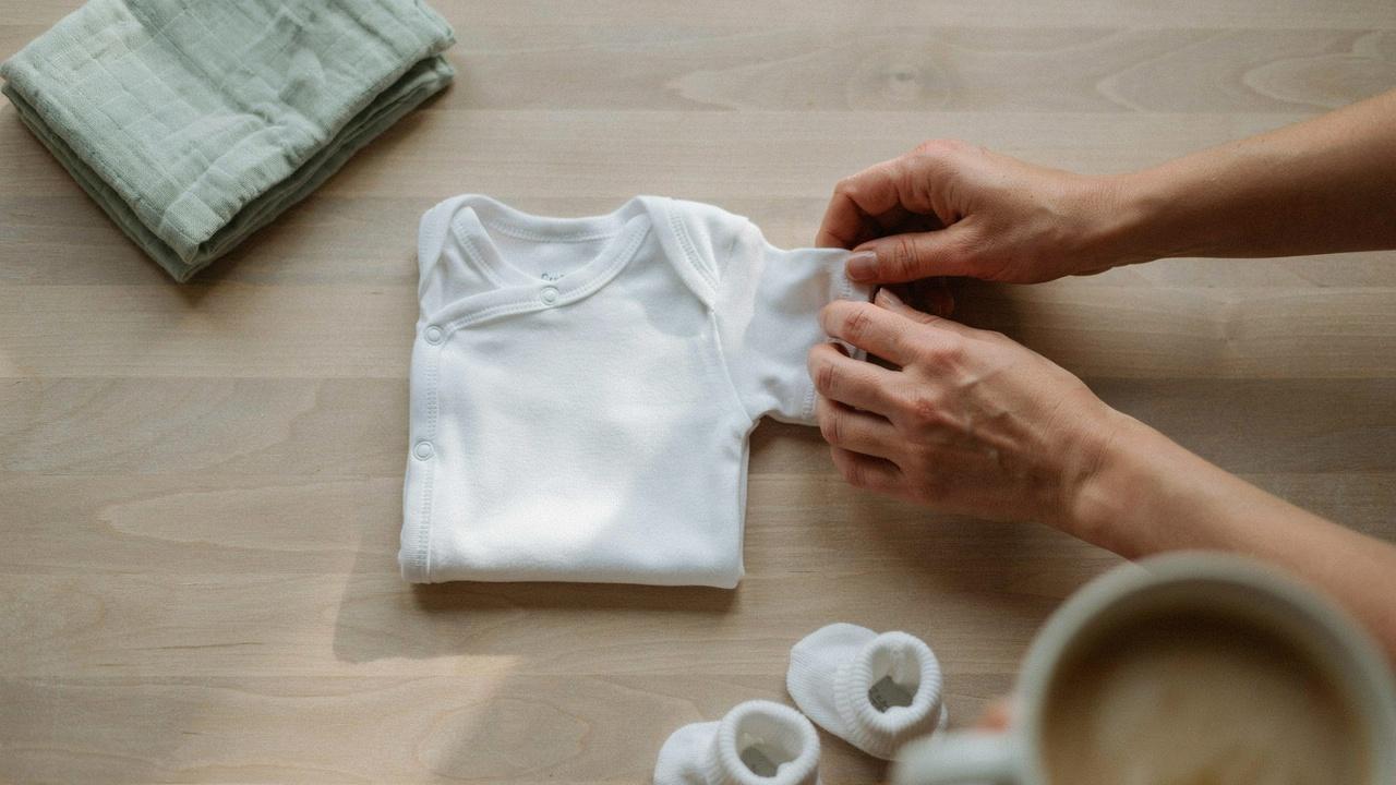 Folding a baby onesie step by step.