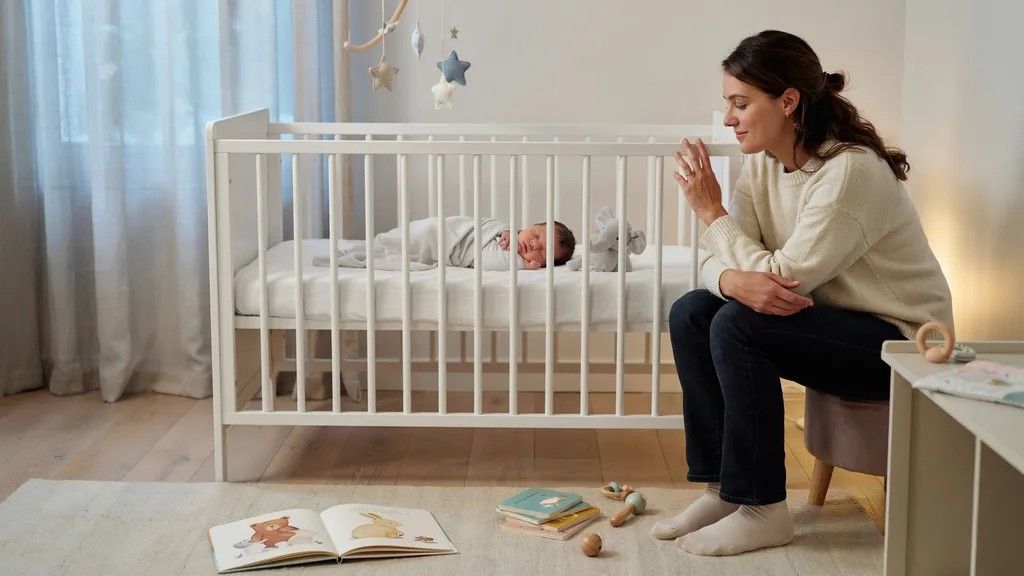 Baby sleeping in a crib while showing the connection between development and sleep changes.