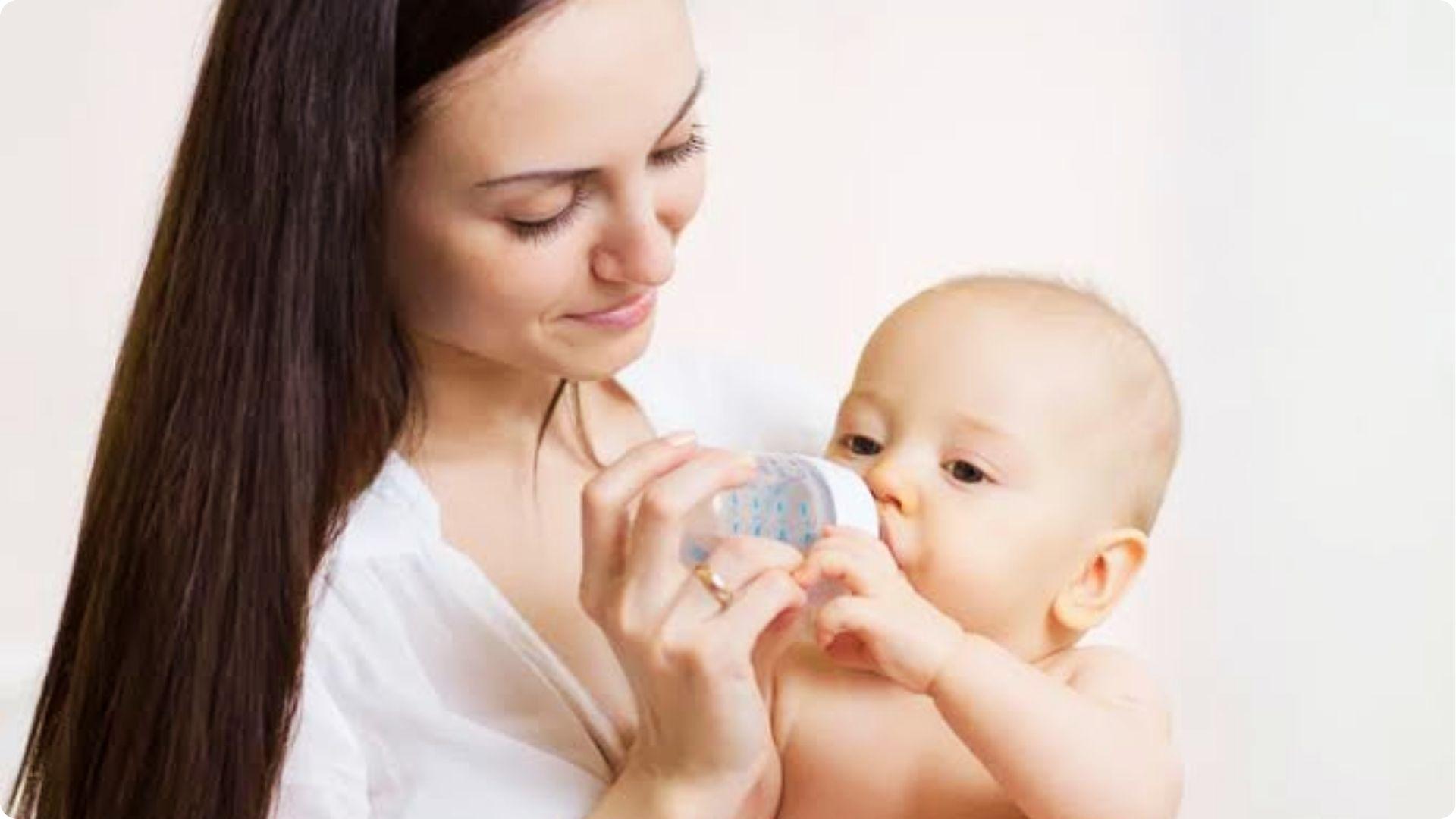 Mother bottle feeding infant baby, comparing coconut water with other baby hydration options