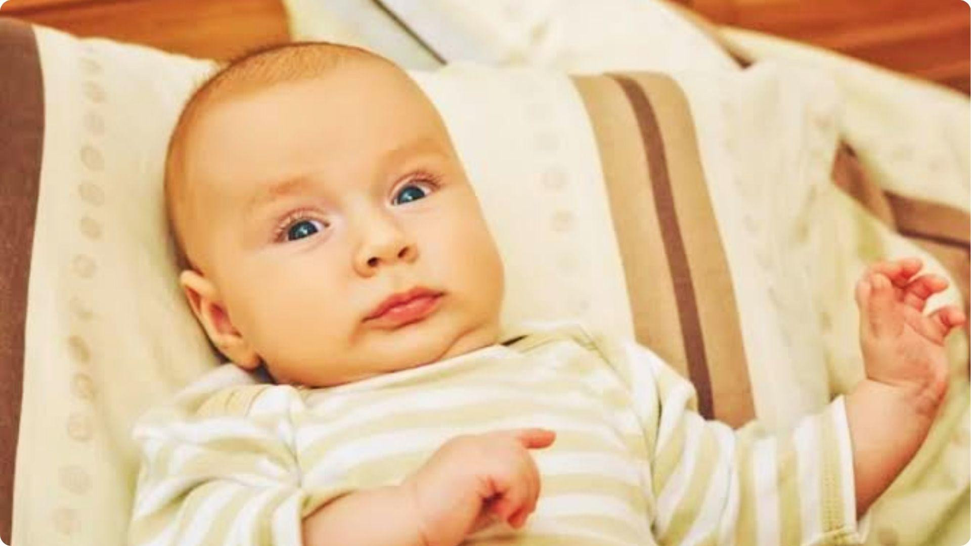 Wide-awake infant lying in bed showing signs of sleep regression and overtired restlessness phase