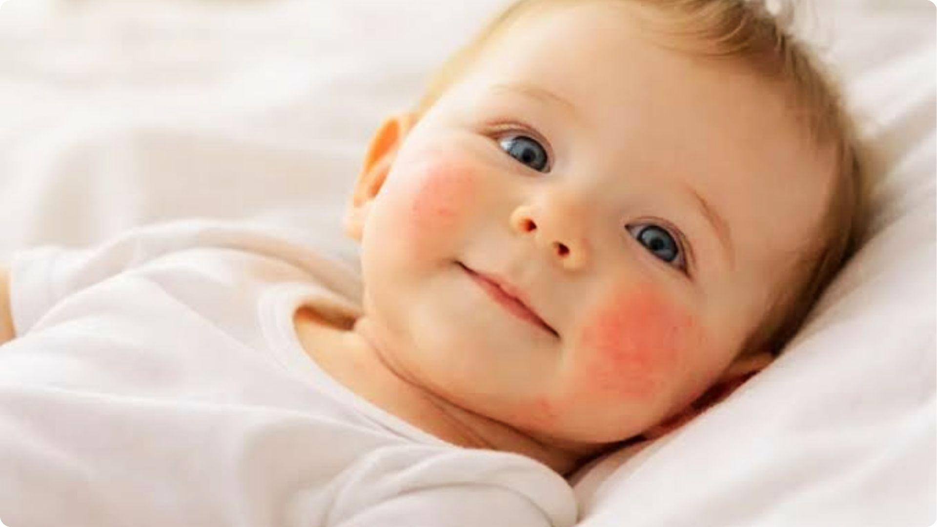 Baby with red rosy cheeks lying on bed, showing warmth and early signs of sweating in infants.