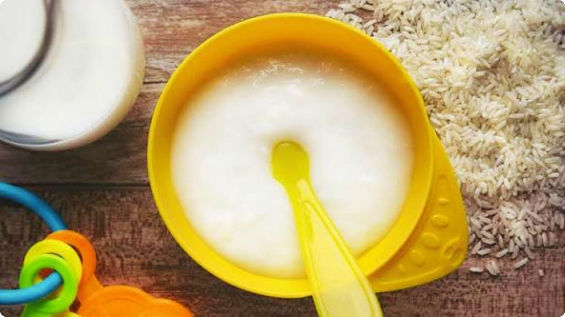 Yellow bowl of smooth rice cereal with milk, often introduced at 4-6 months to meet iron needs.