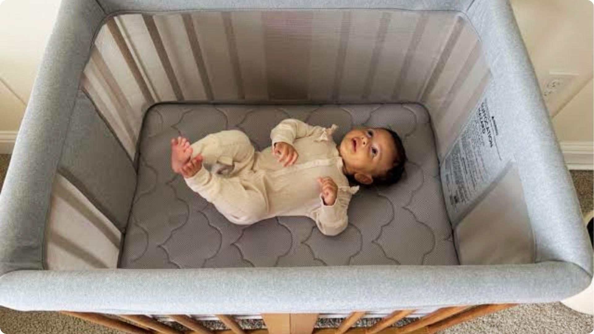Baby lying awake in bassinet crib during sleep regression stage with disrupted nap pattern