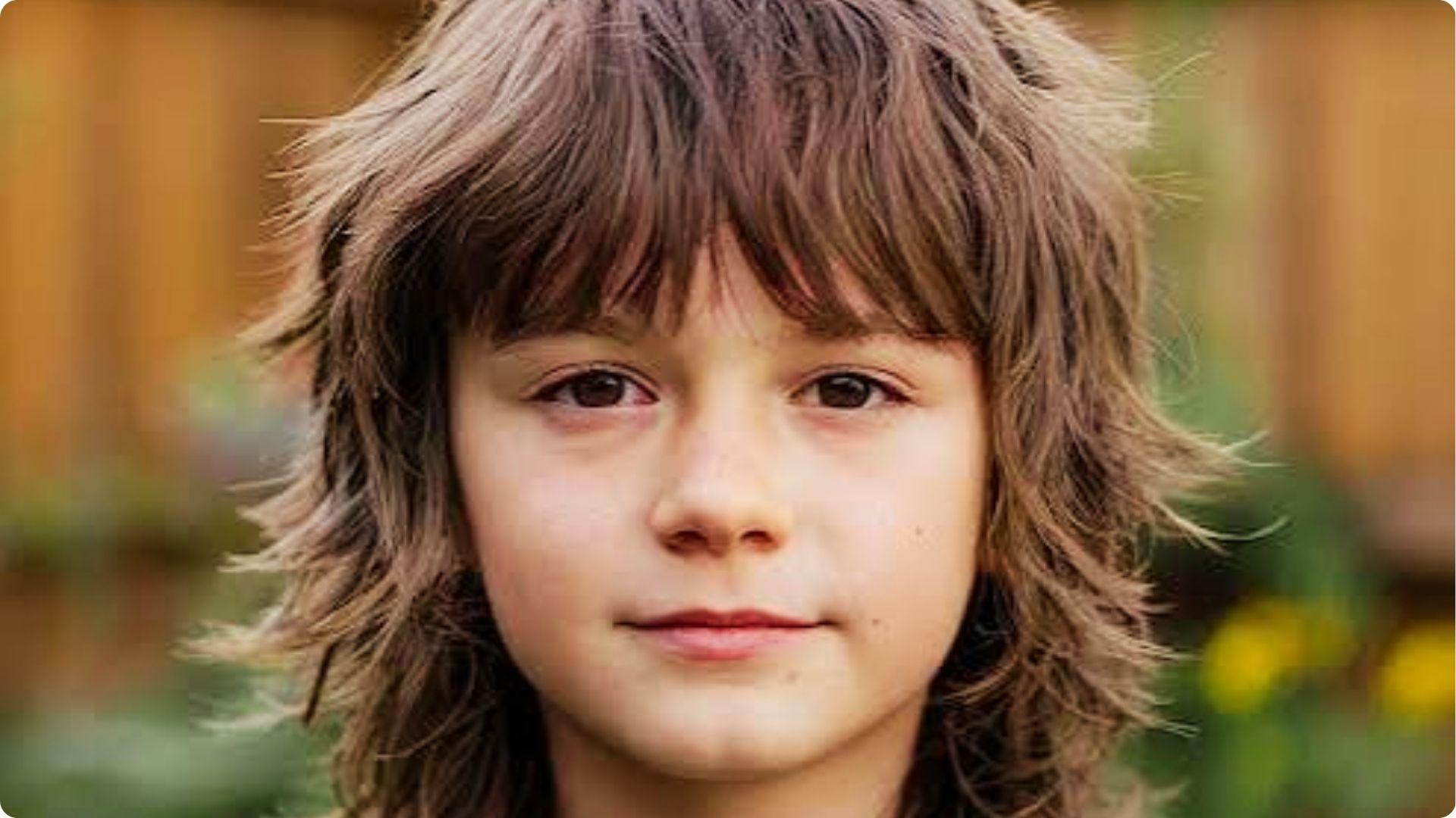 Child outdoors with shaggy wavy layered cut and soft bangs, natural messy texture, cute boy haircut