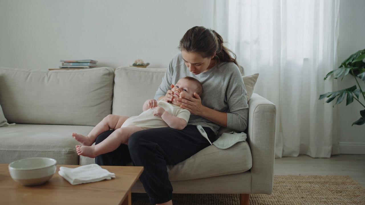Parent checking baby's red cheeks to identify the possible cause.