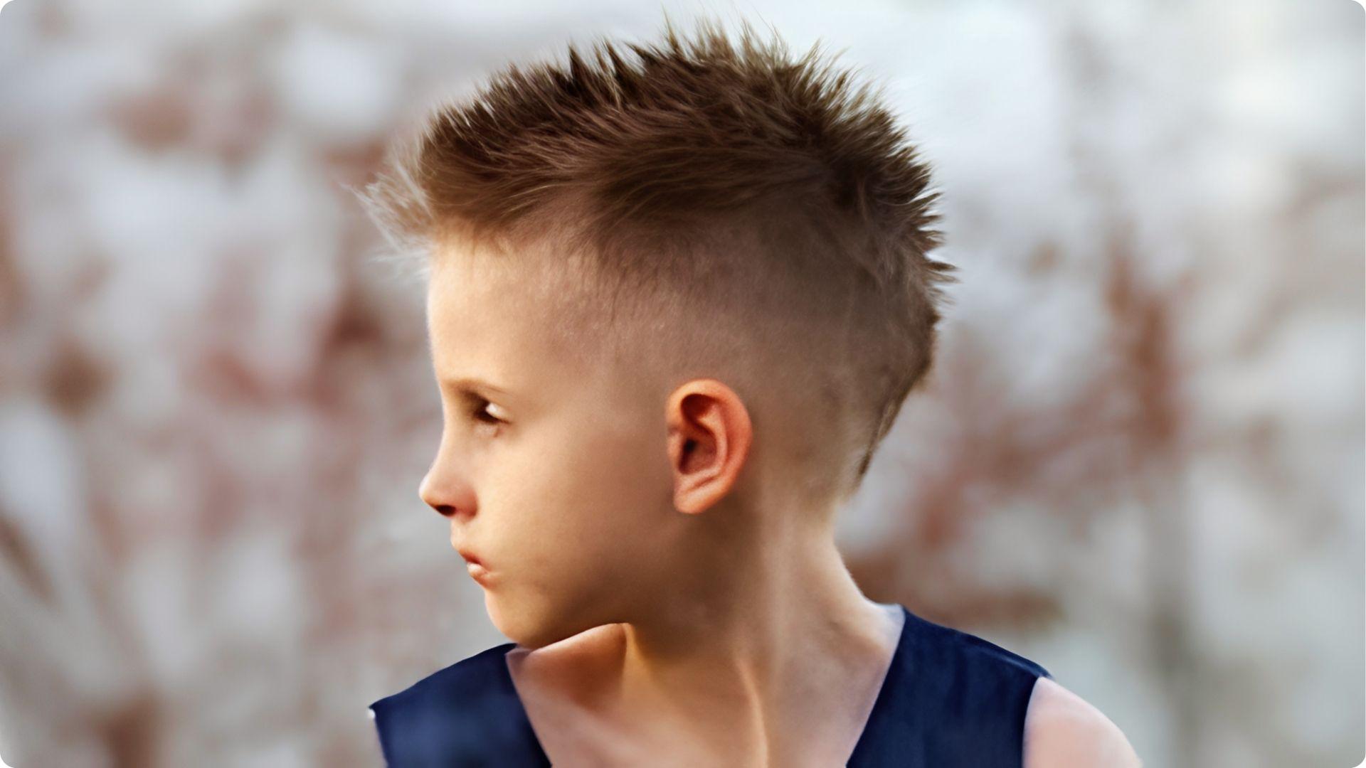 Toddler with French crop fringe and high skin fade, straight bangs forward, clean modern baby boy cut.