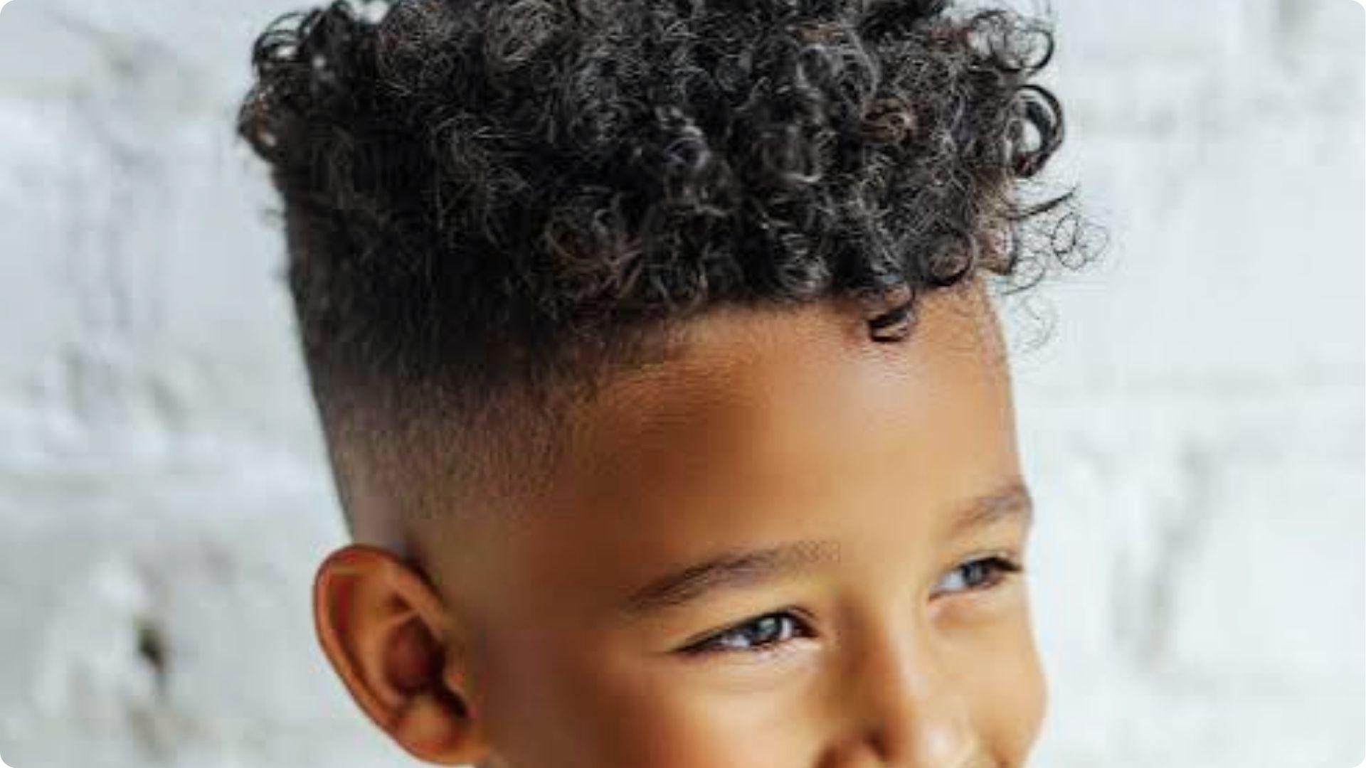 Blonde toddler profile with textured quiff and high skin fade, swept-up fringe, trendy baby boy style.