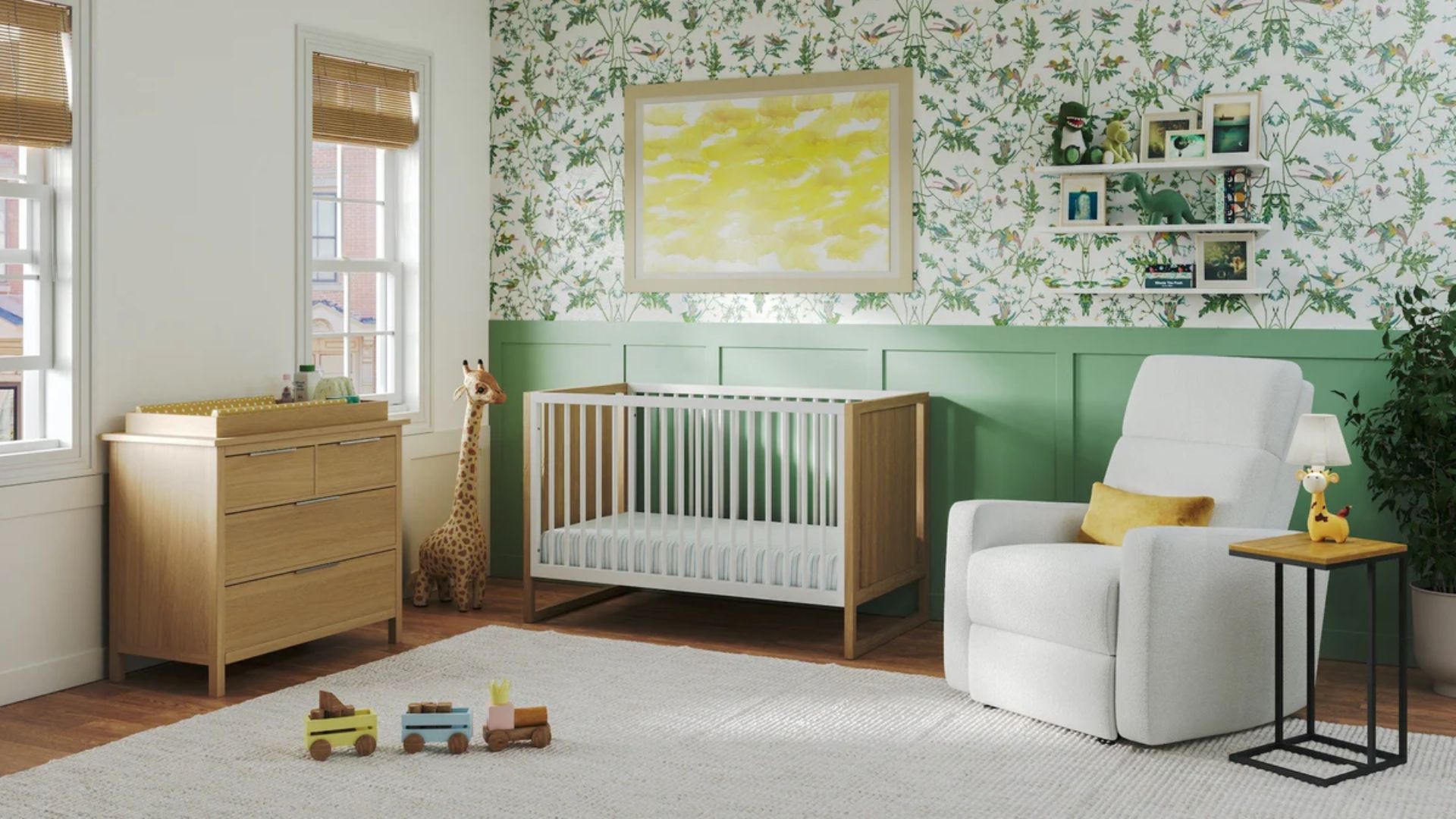 Bright green and white nursery with white wood crib, wooden dresser, white recliner with yellow pillow, giraffe plush and toy trains on rug.