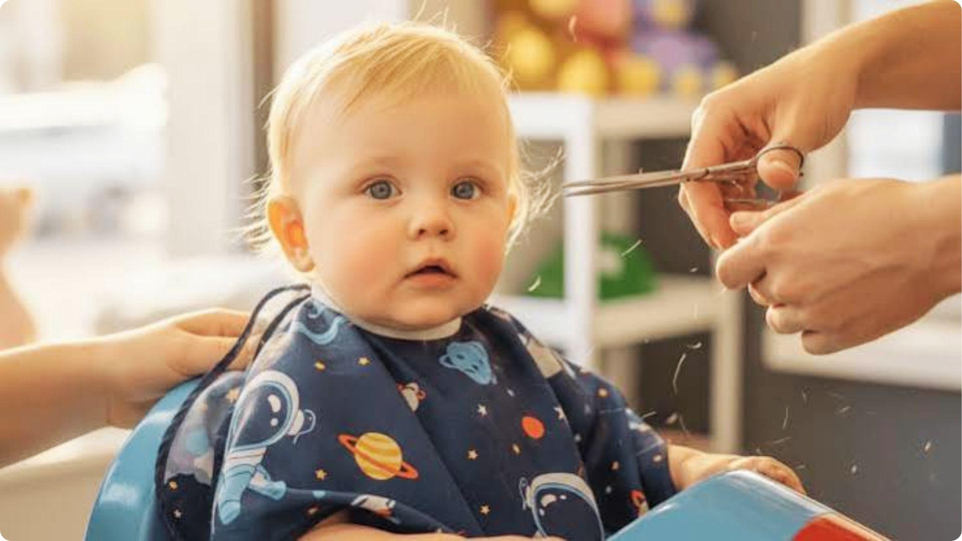 Baby getting first haircut with scissors trimming fine blonde hair, space cape, cute baby boy trim.