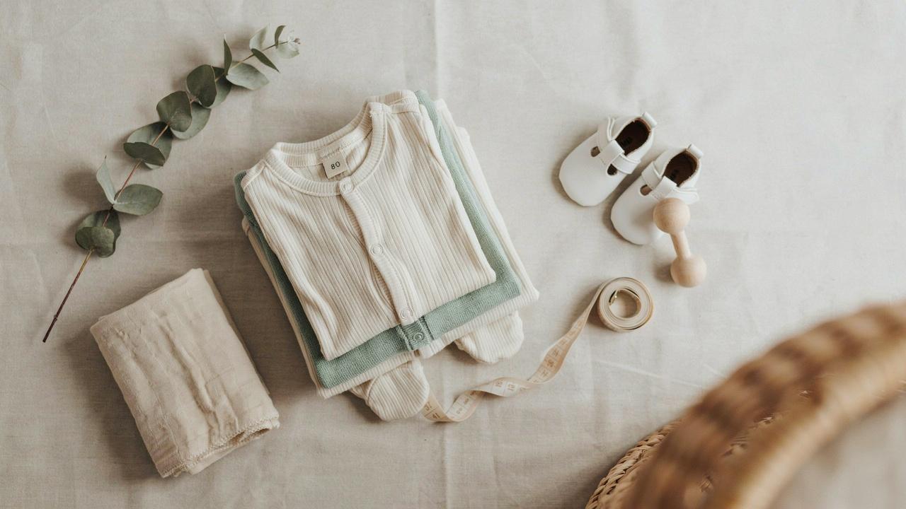 European size 80 baby clothes with measuring tape and baby essentials.