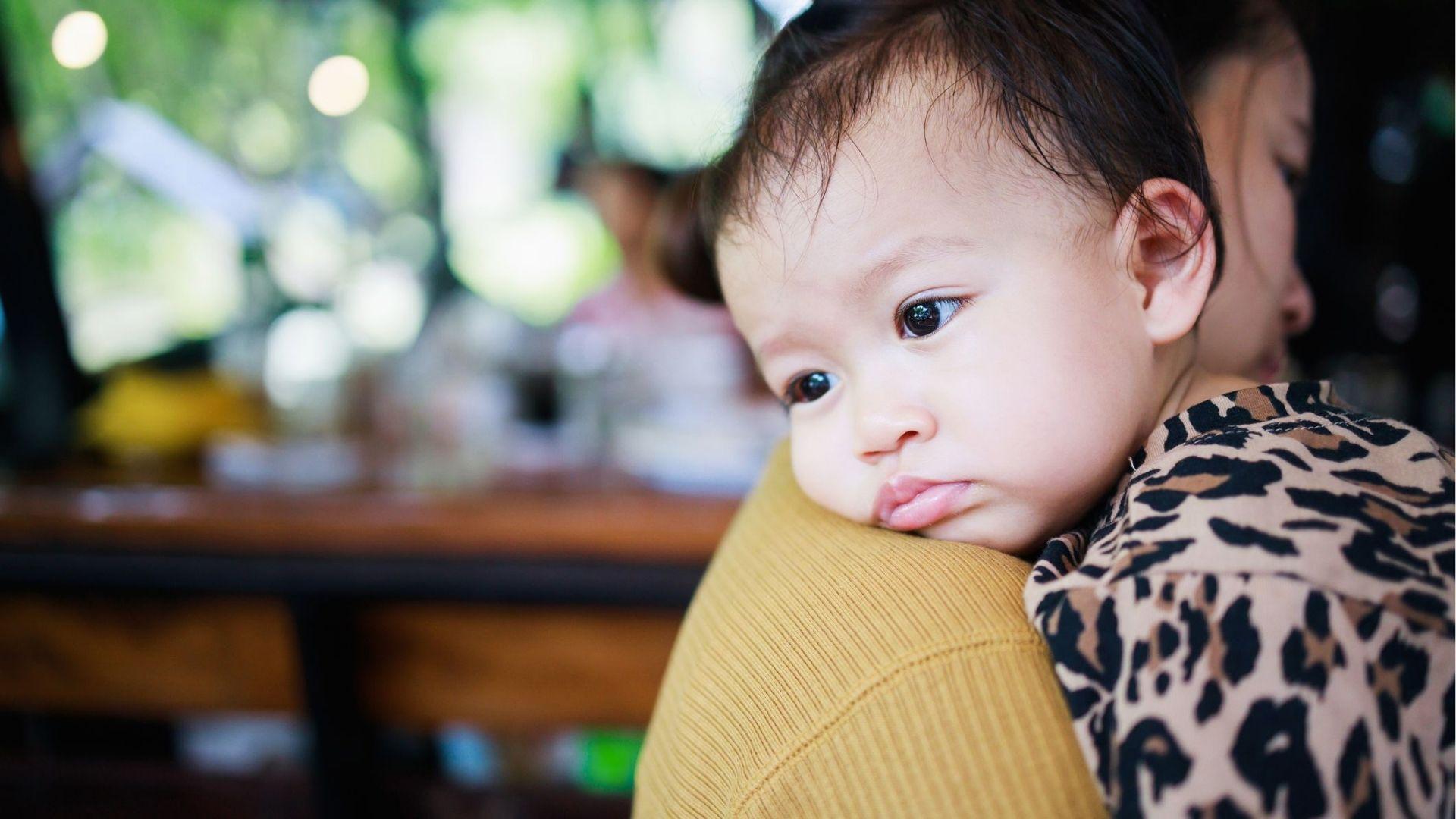 Baby resting against an adult's shoulder
