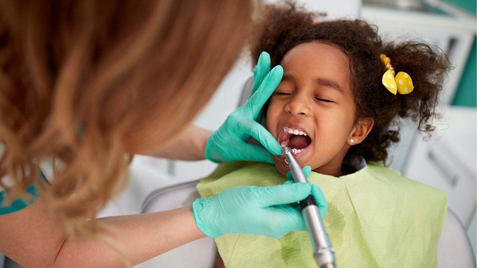 Child receiving a routine dental checkup to monitor healthy molar development.