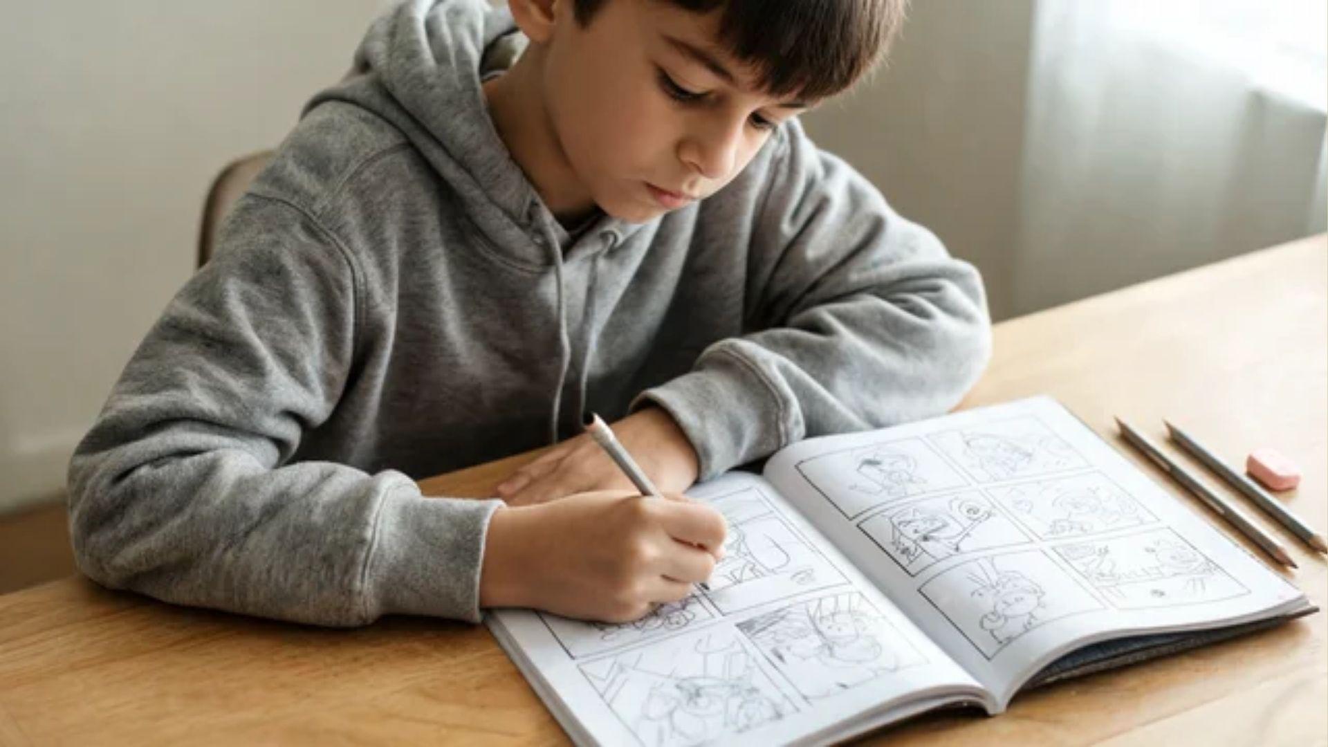 Child drawing comic panels in an open booklet with a pencil at a table