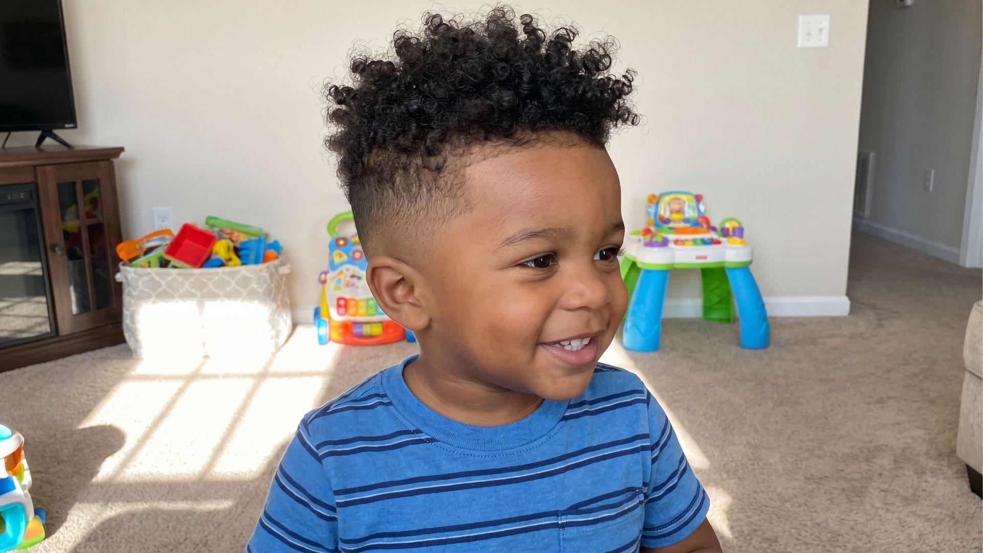 Fade short low maintenance toddler boy haircut with a low fade and natural curly top