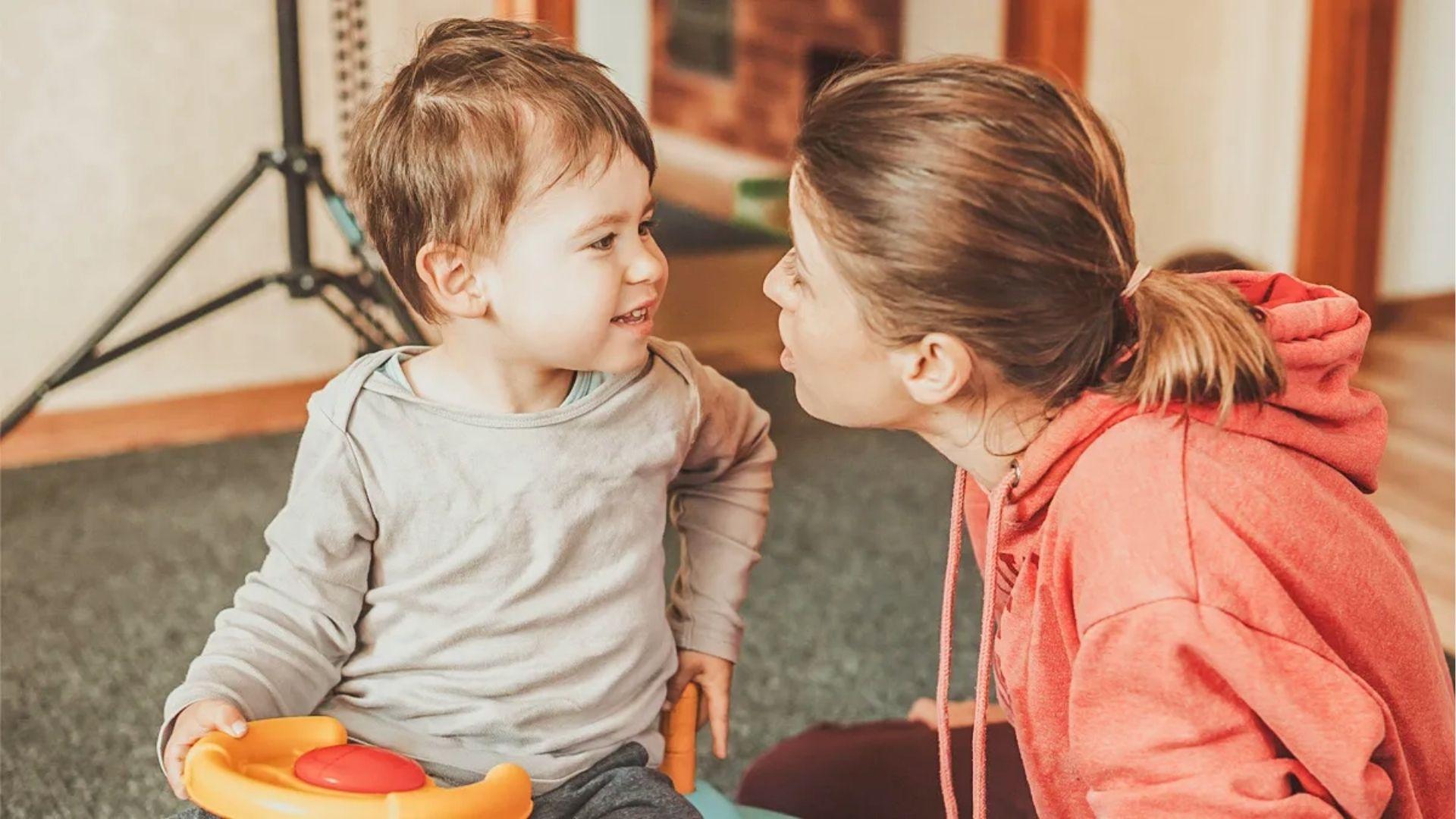 Mother face-to-face with baby boy encouraging speech.