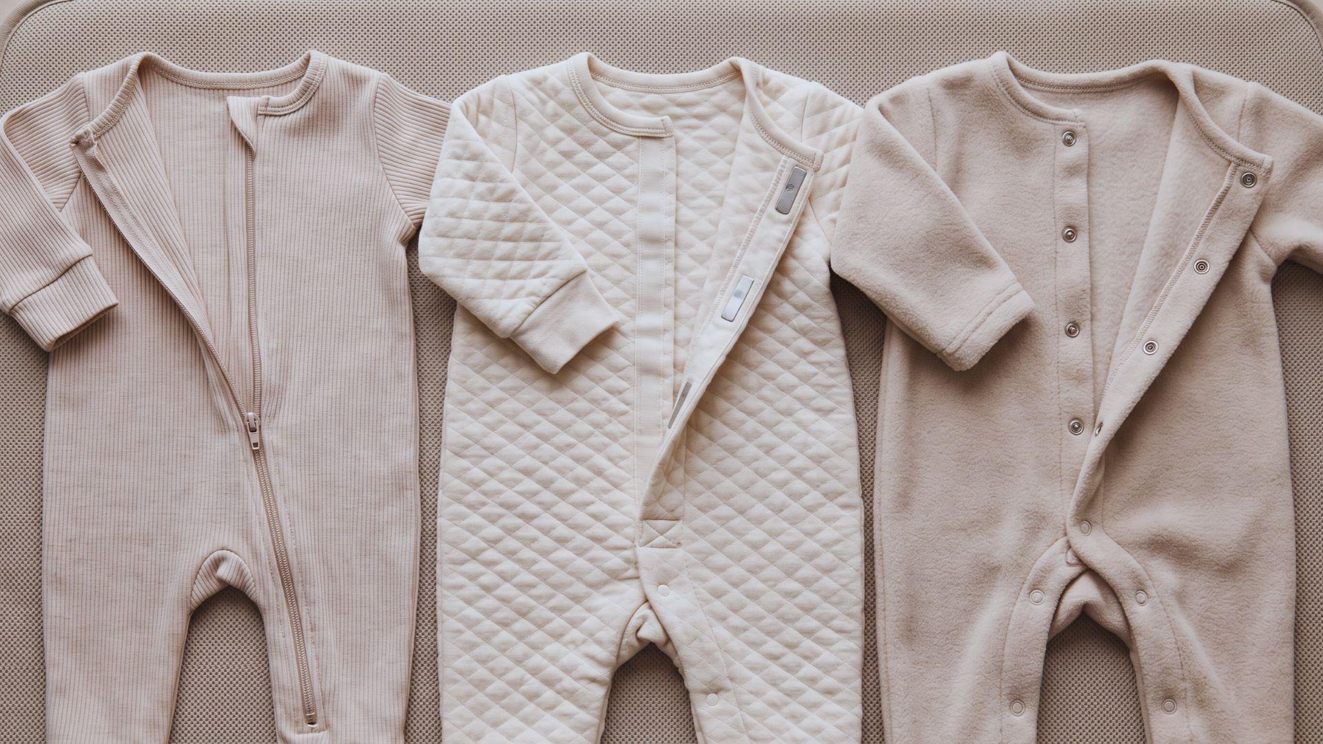Three newborn sleepers display a zipper, magnetic closure, and snap fasteners.