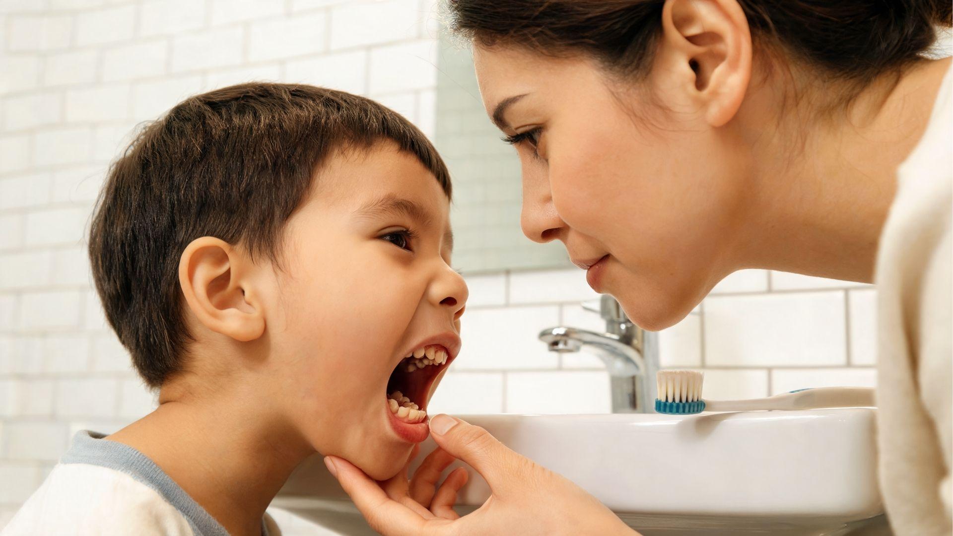 Parent checking a child's newly erupting molars during a daily oral care routine.
