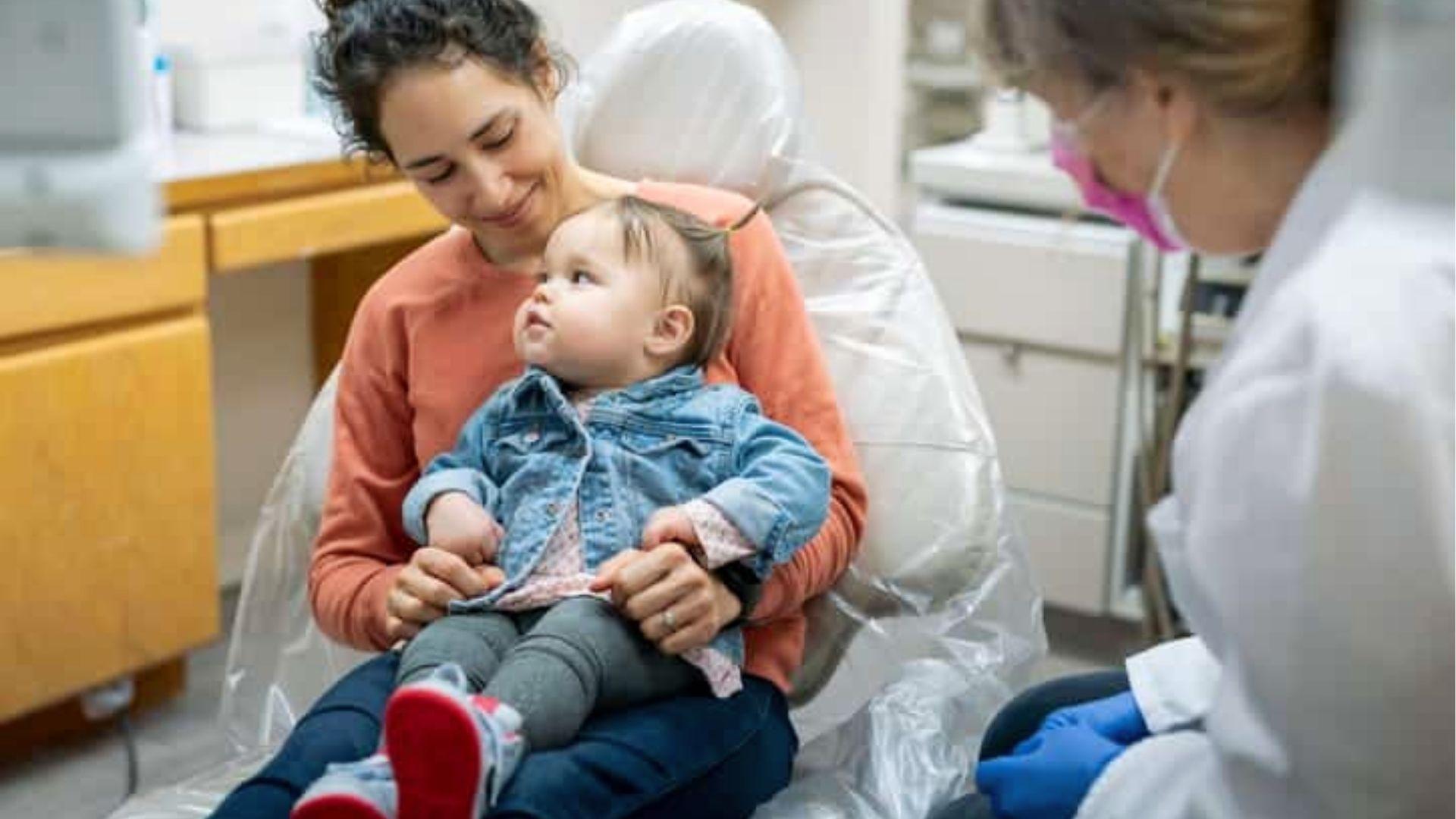 Baby on mom’s lap at dental clinic