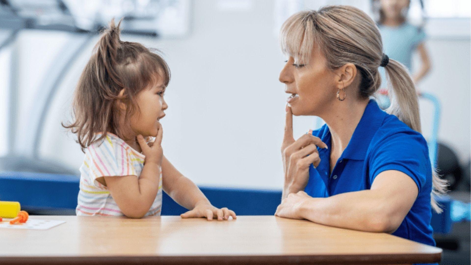Speech therapist teaching toddler to say words.