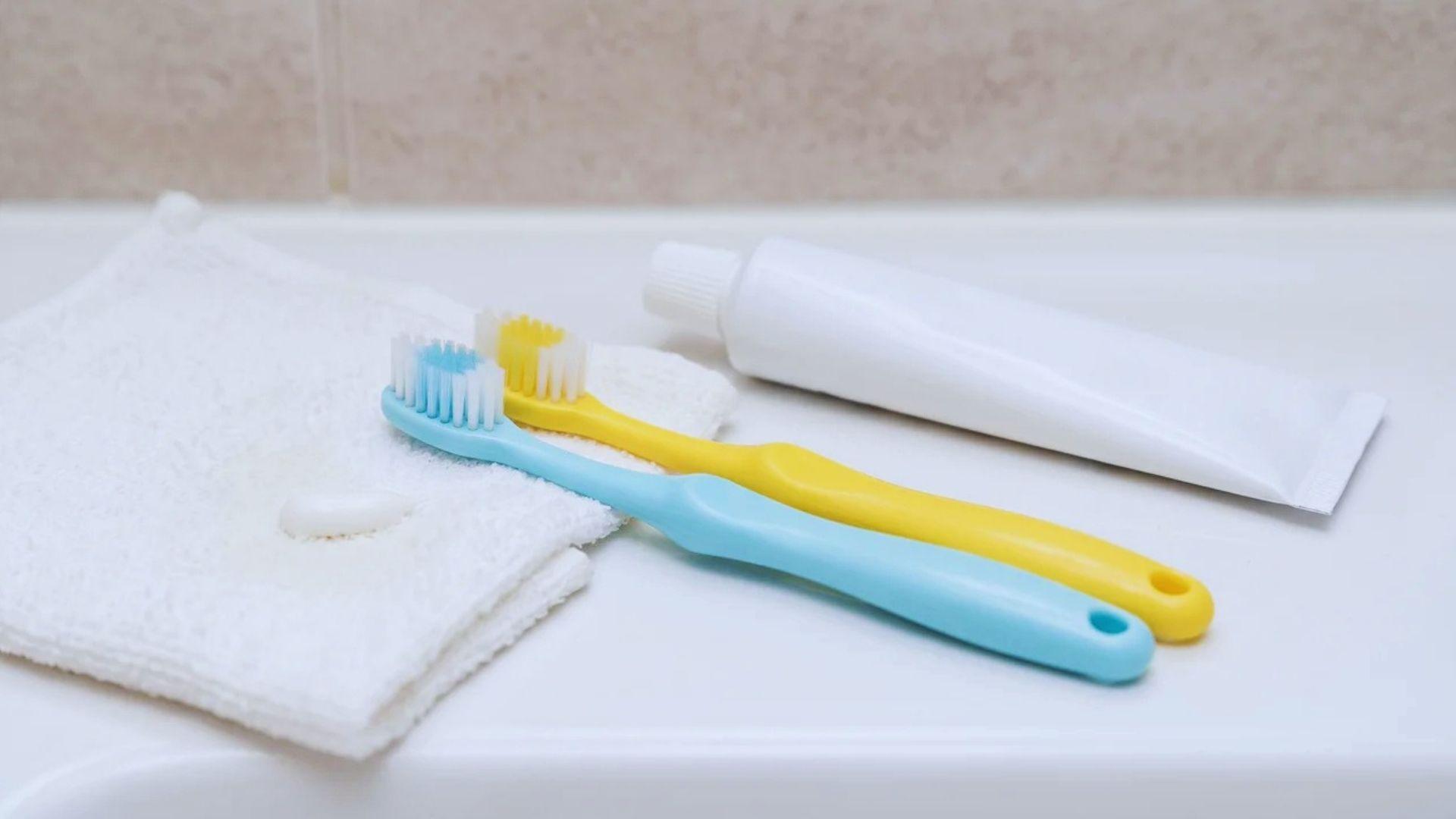 Two children's toothbrushes and fluoride toothpaste arranged on a bathroom counter.